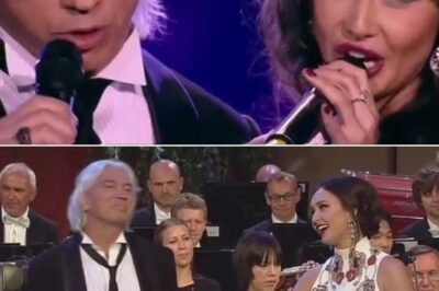 Under the spotlight of the grand stage, the atmosphere is filled with anticipation as Aida Garifullina and Dmitri Hvorostovsky take their places, ready to deliver a performance that promises to be unforgettable. The orchestra swells to life, and as the first delicate notes of Deja Vu by Igor Krutoy fill the air, the audience is immediately transported to a place of emotional depth and beauty. Aida’s voice, light and shimmering, contrasts perfectly with Dmitri’s deep, resonant baritone, their powerful duets weaving together a story of longing and connection. The crowd is mesmerized, held in the grip of the incredible chemistry between the two, whose voices blend in perfect harmony, their passion for the piece evident in every note.