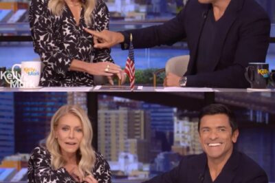 Mark Consuelos reaches over to rub wife’s torso after mic falls ‘deep into the cleavage’. See what they do next.